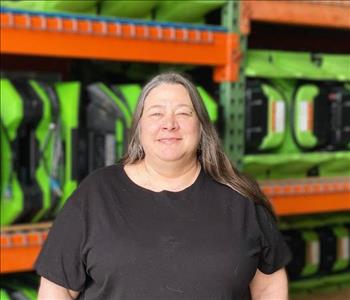 Dawn is standing in front of a wall of green air movers